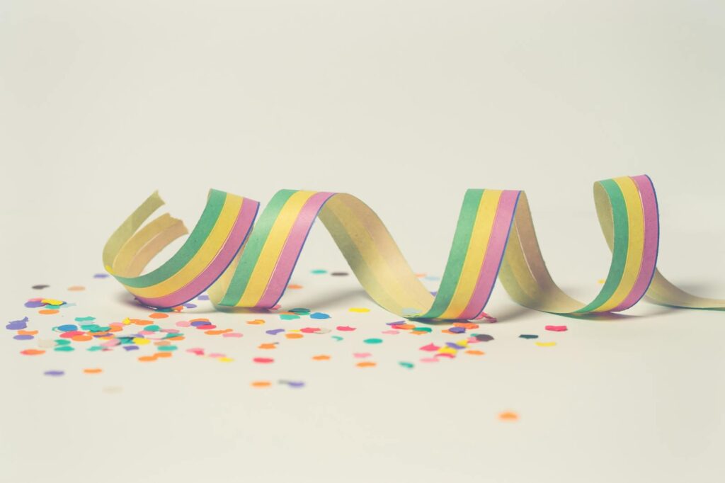 Bright pastel paper streamer with scattered confetti, perfect for celebration themes.